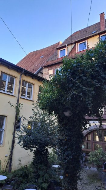 Das Foto zeigt den schattigen Innenhof der Bücherei im Pfleghof an einem schönen Sommertag.